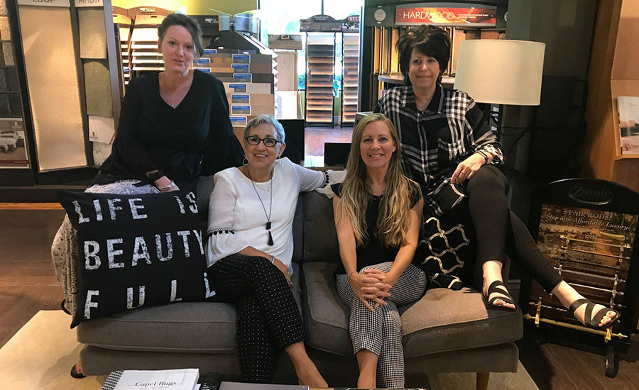 Cherry Carpet team sitting on couch inside showroom