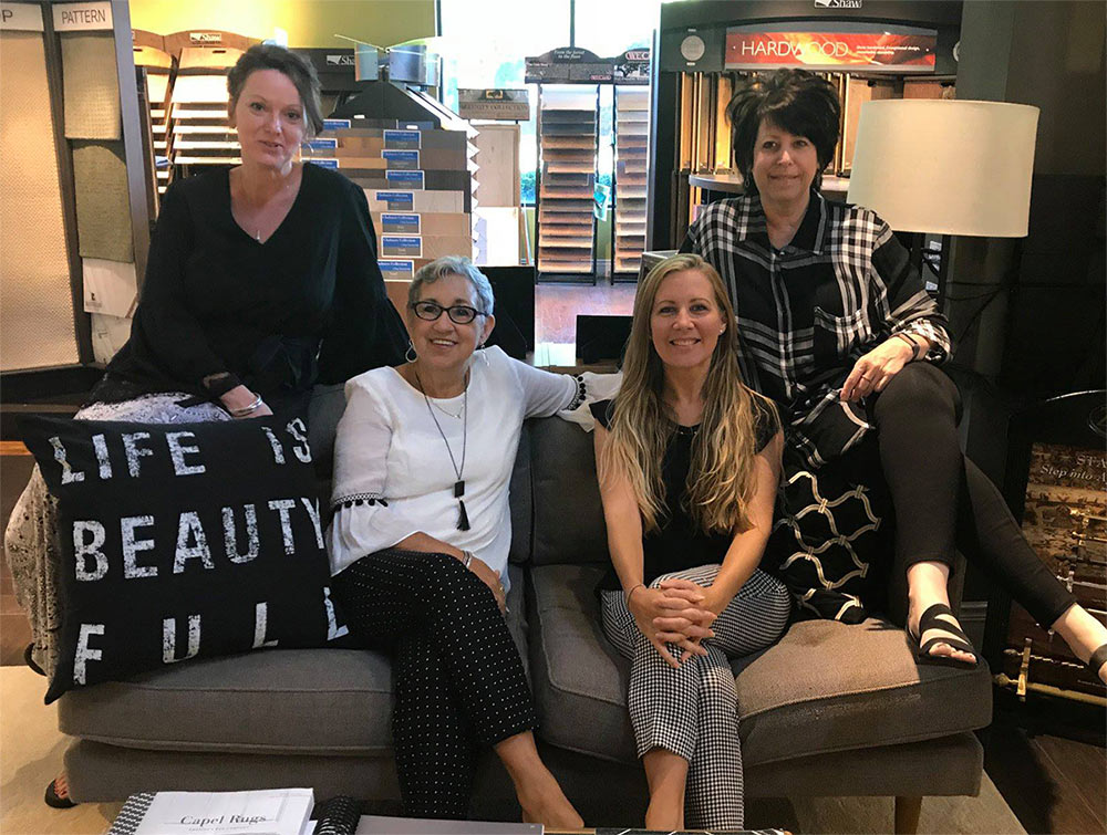 Cherry Carpet team sitting on couch inside showroom