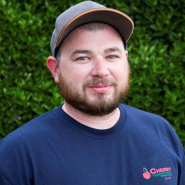 James Aemisegger headshot in front of green bush