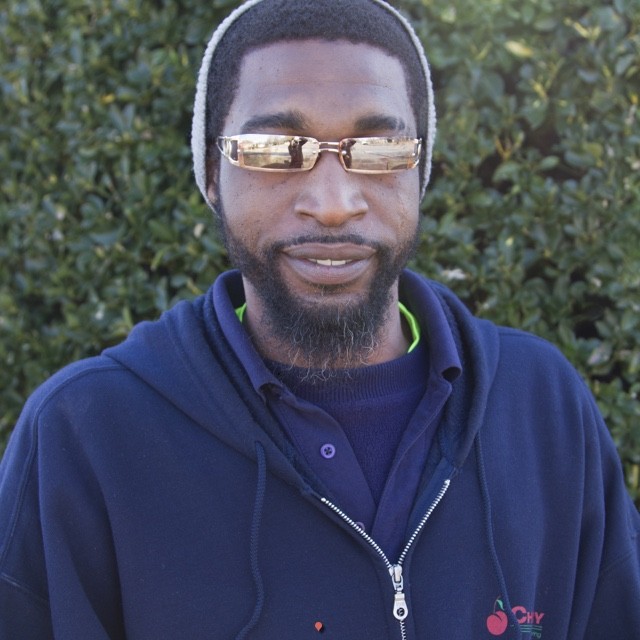 Quintin Bailey headshot in front of green bush