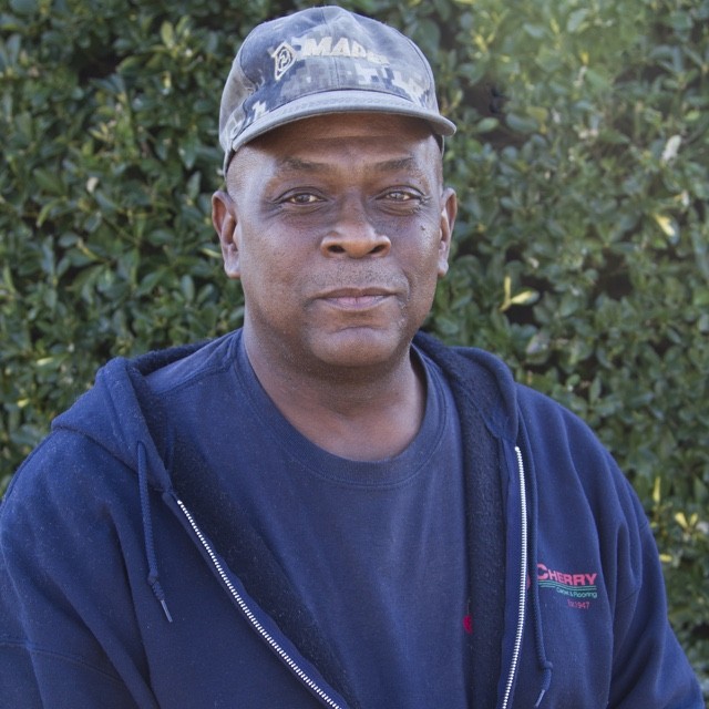 Richard Dillard headshot in front of green bush