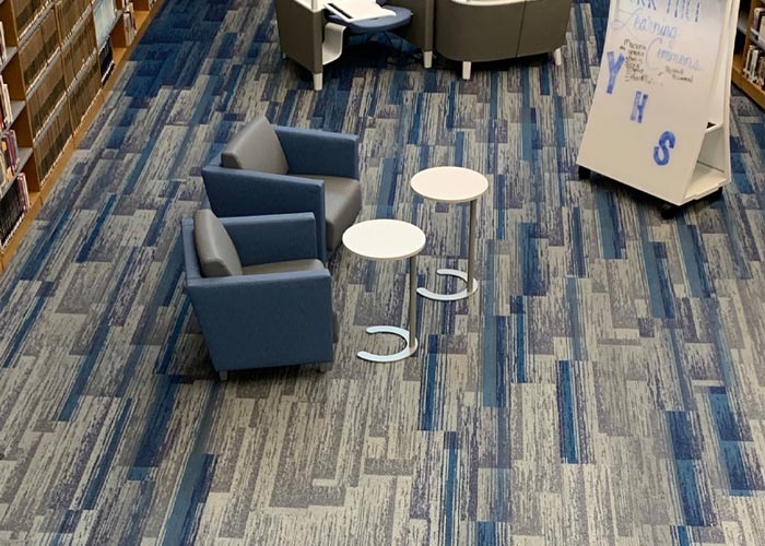 Aerial view of blue and gray carpet flooring and chairs in commercial space
