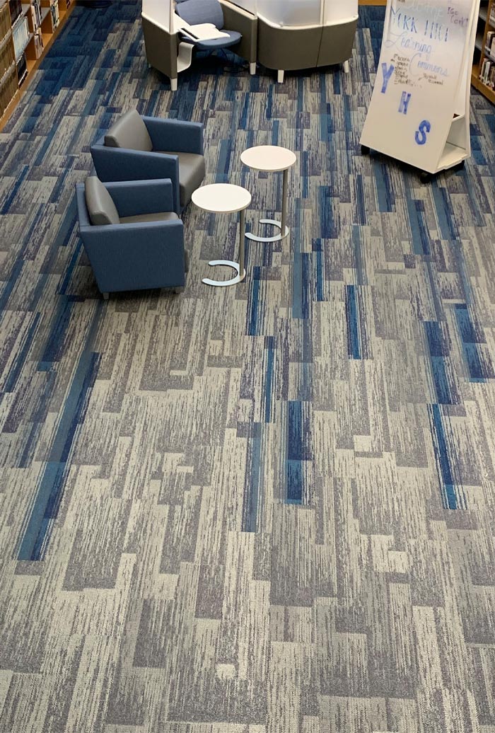 Aerial view of blue and gray carpet flooring and chairs in commercial space