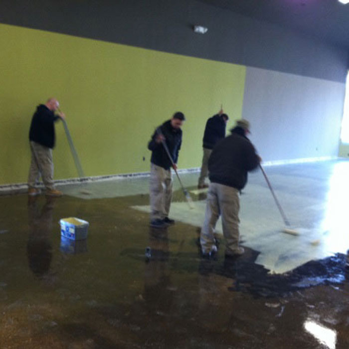 Group of flooring installers using moisture mitigation techniques in large commercial building