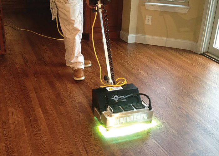 Hardwood floor being refinished by installer