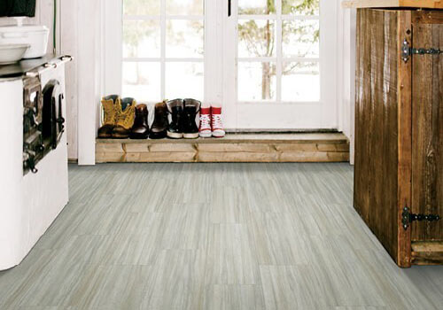 Gray laminate floor in mud room with boots lined up
