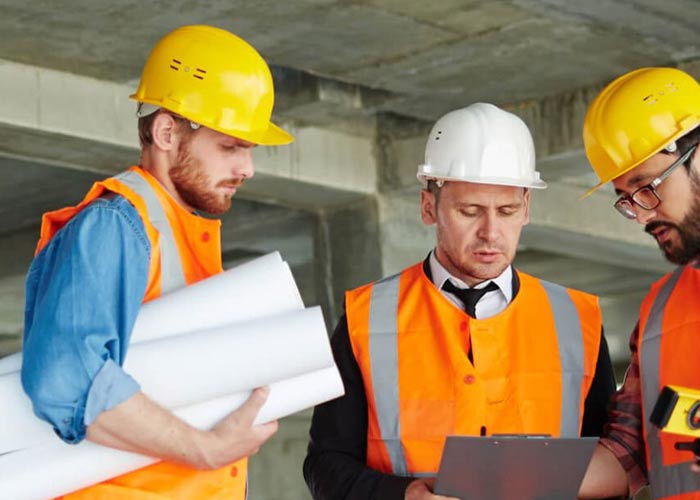 Construction workers discussing plans and looking at clipboard