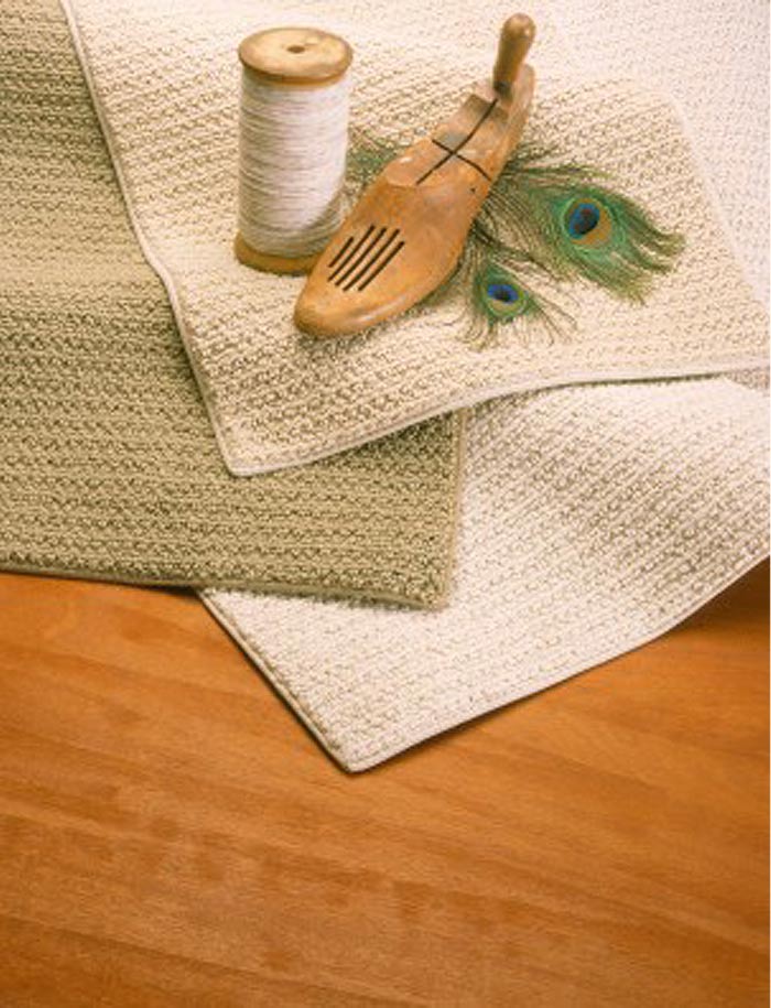 String, wood shoe insert, and feathers sitting on top of a pile of rugs